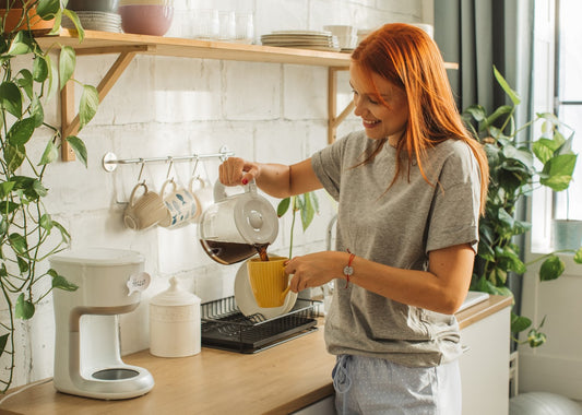 Young female pouring coffee into a cup